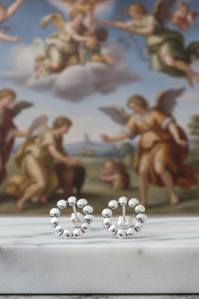 Antik fresk önünde mermer zemin üzerinde sergilenen 925 ayar gümüş bubble küpeler